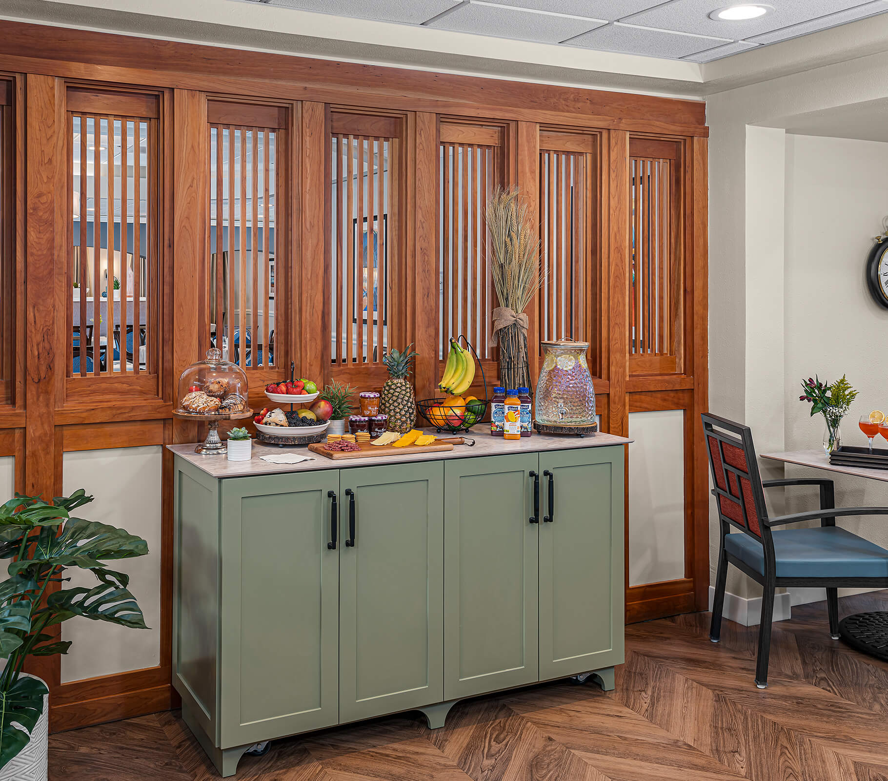 Elegant snack station with fresh fruits and pastries in a cozy communal area.