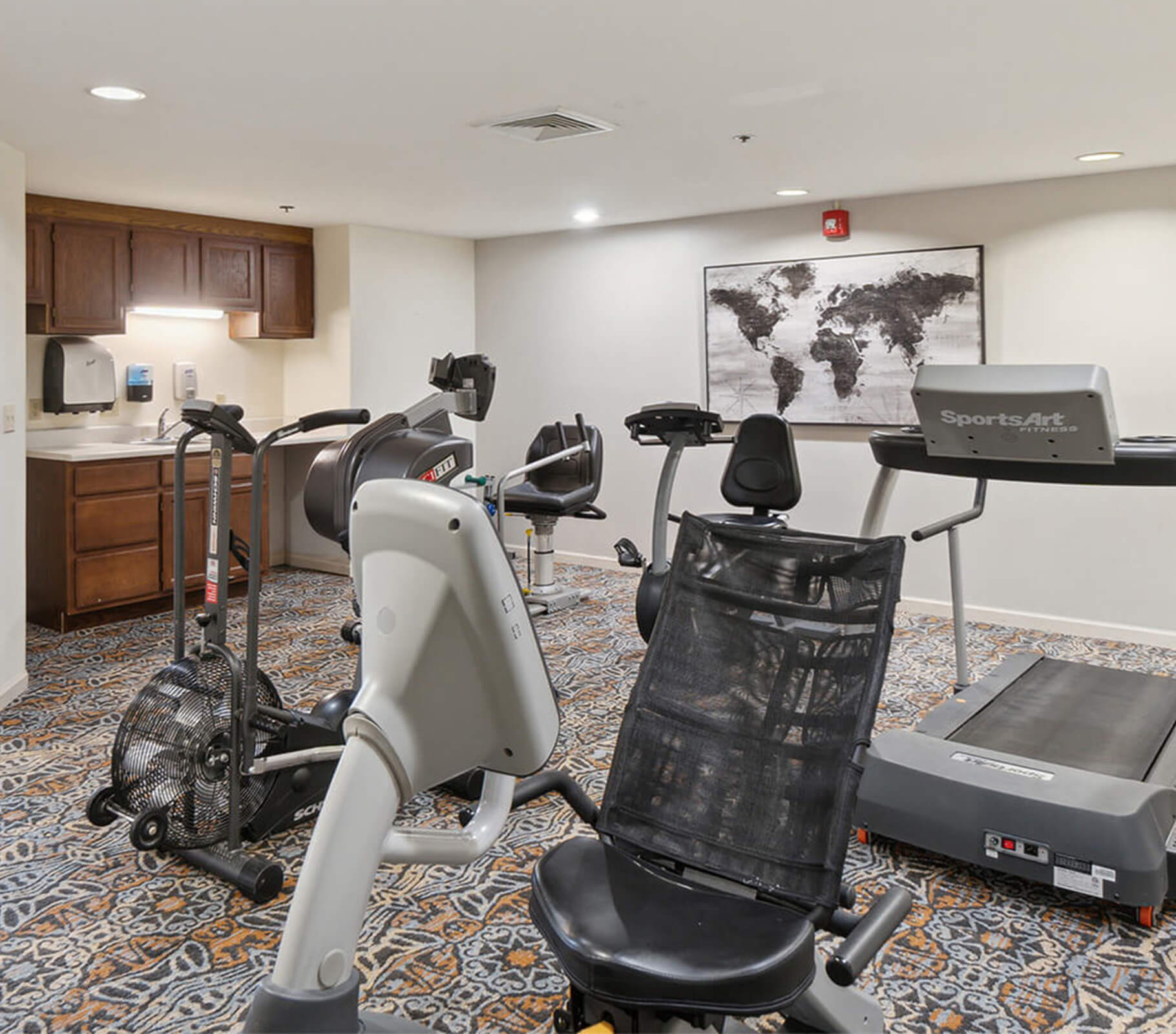 Exercise room in a community building with treadmills and stationary bikes.