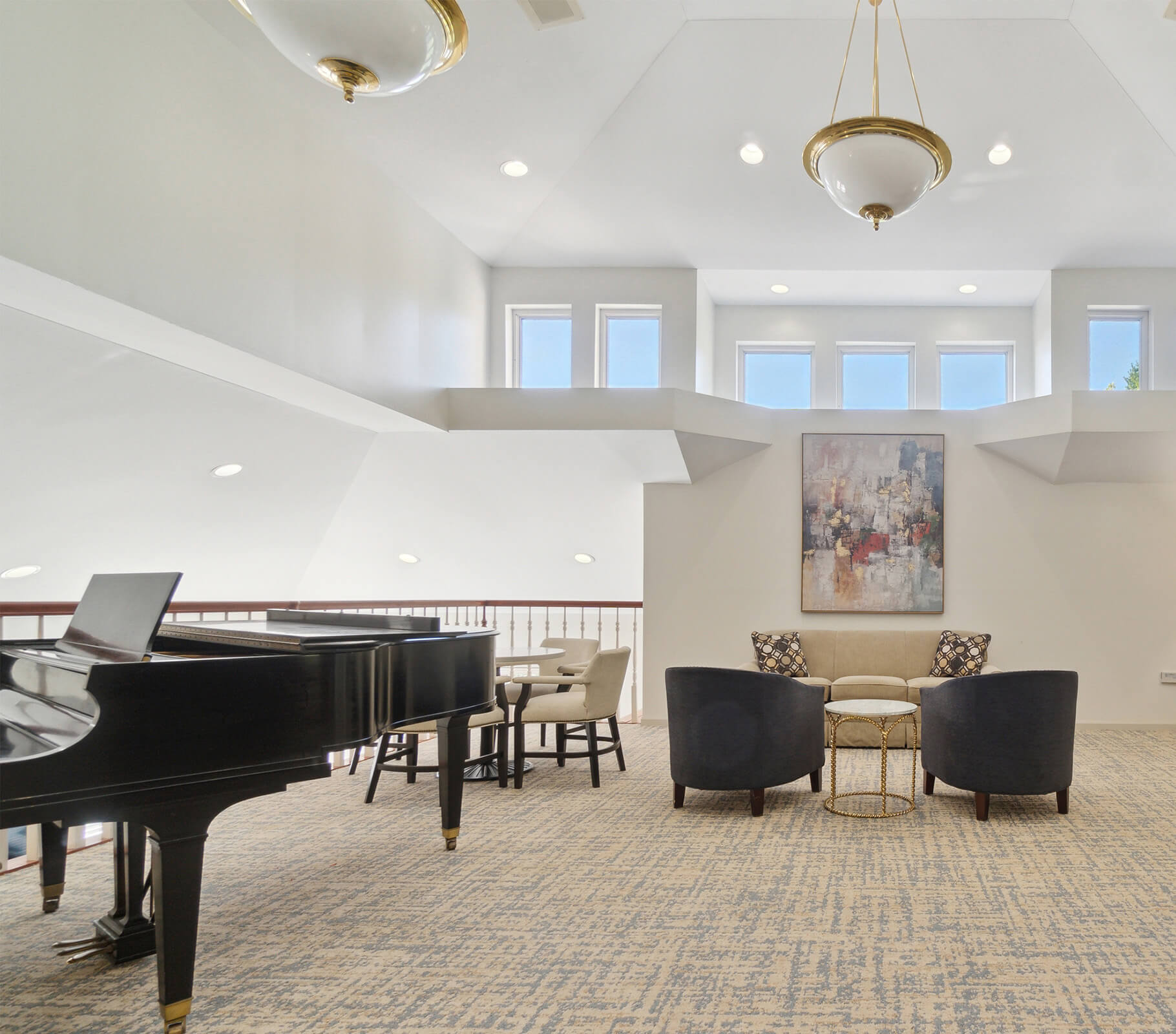 Bright communal room with grand piano, seating area, and modern art in senior complex.