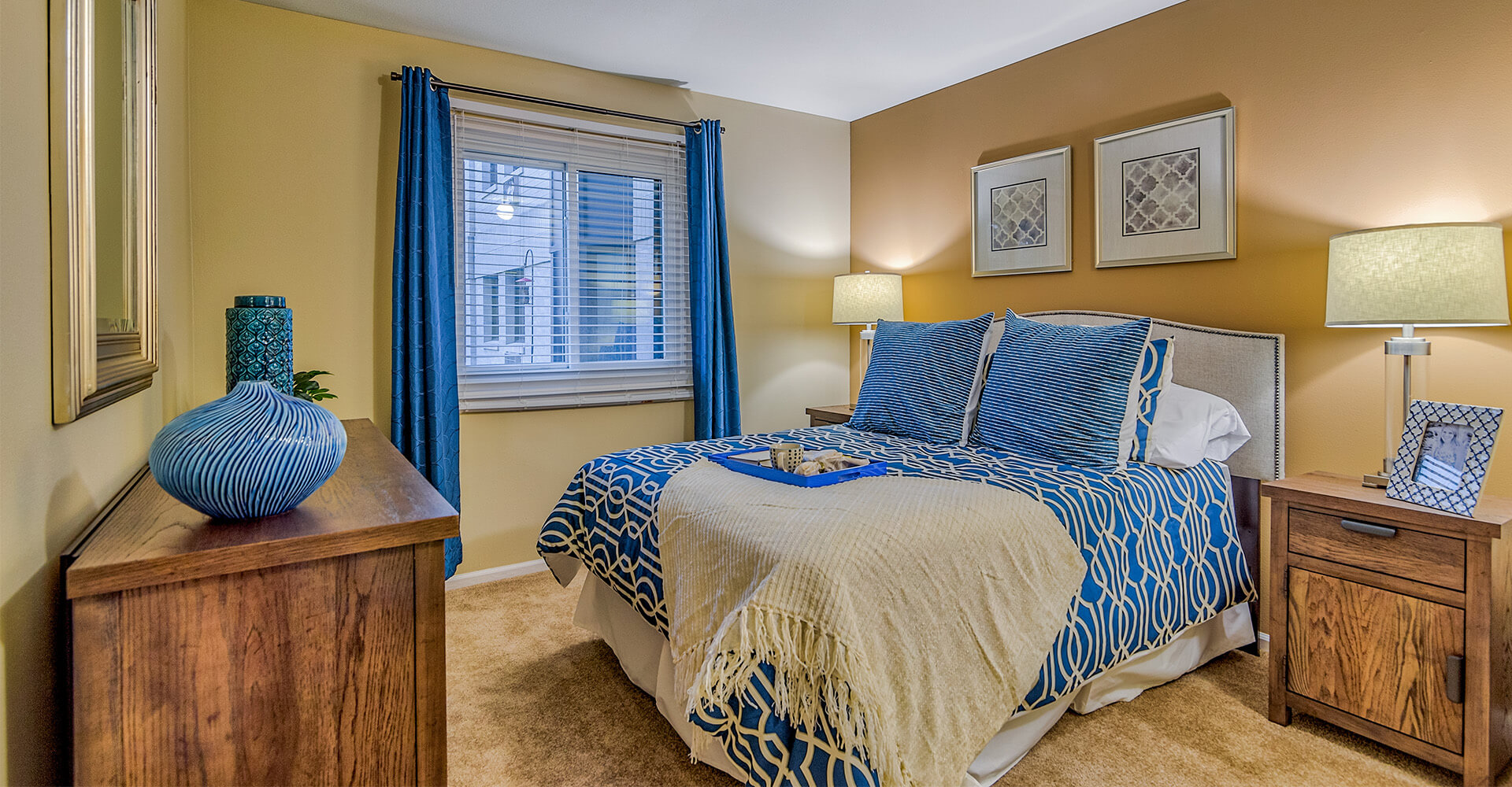 Cozy bedroom with a blue and beige color scheme and wooden furniture.