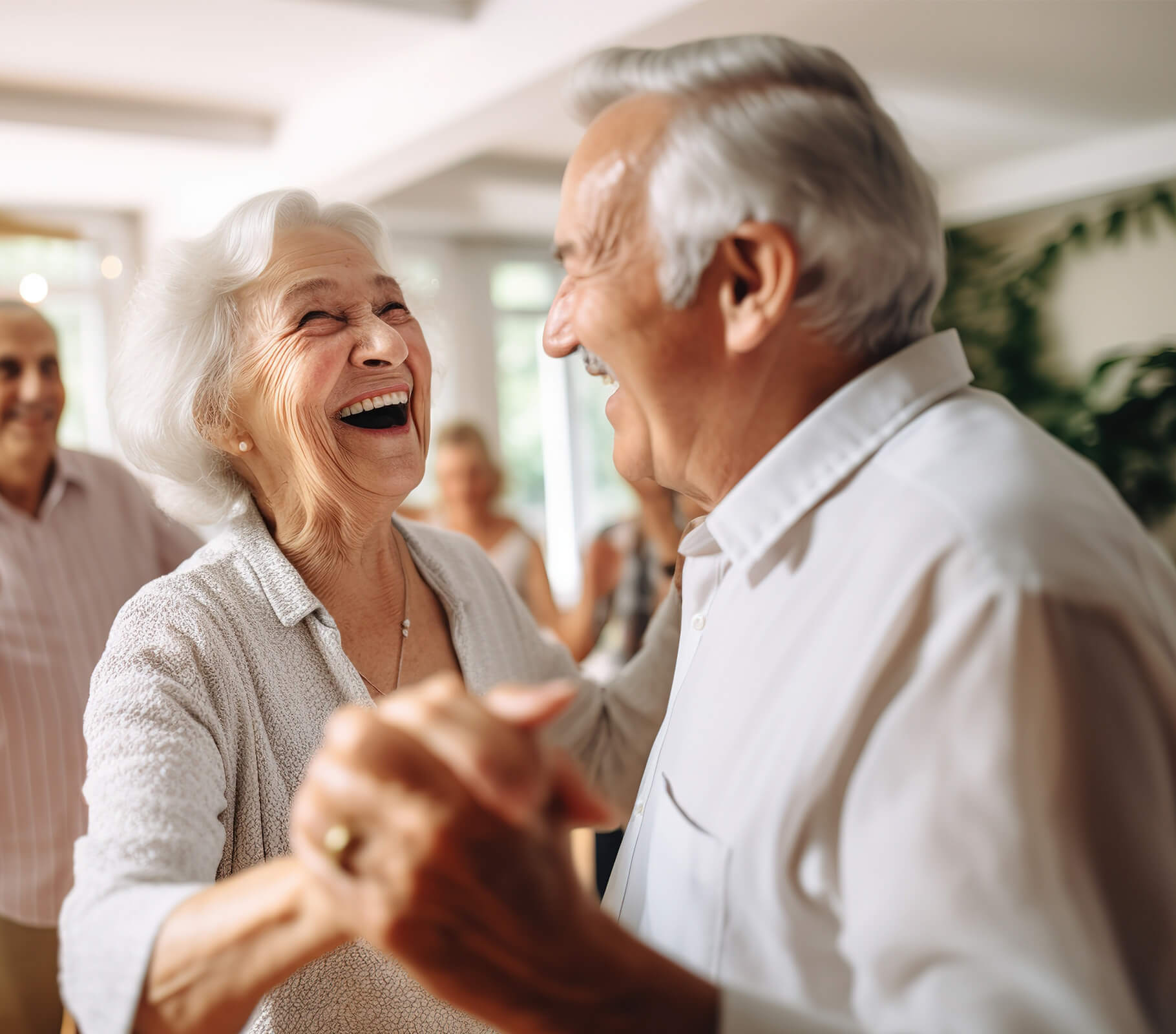 Elderly couple joyfully dancing together in a bright community room.