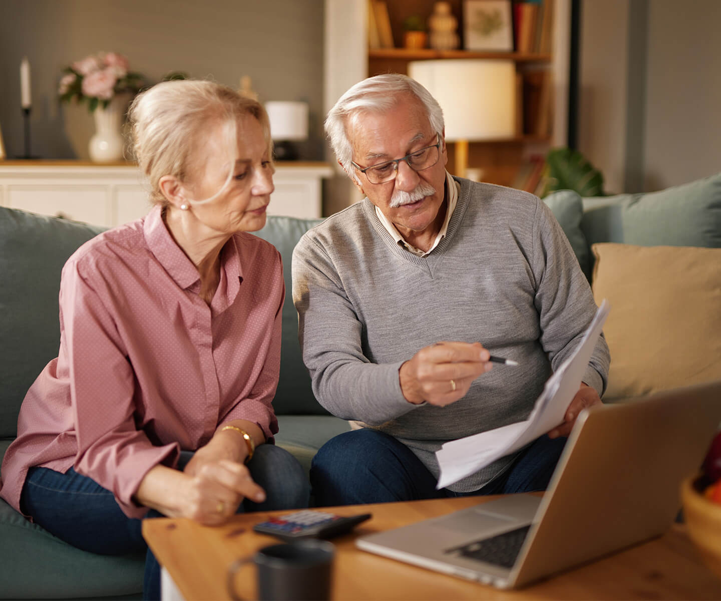 Elderly couple reviewing documents in a cozy living room setting.