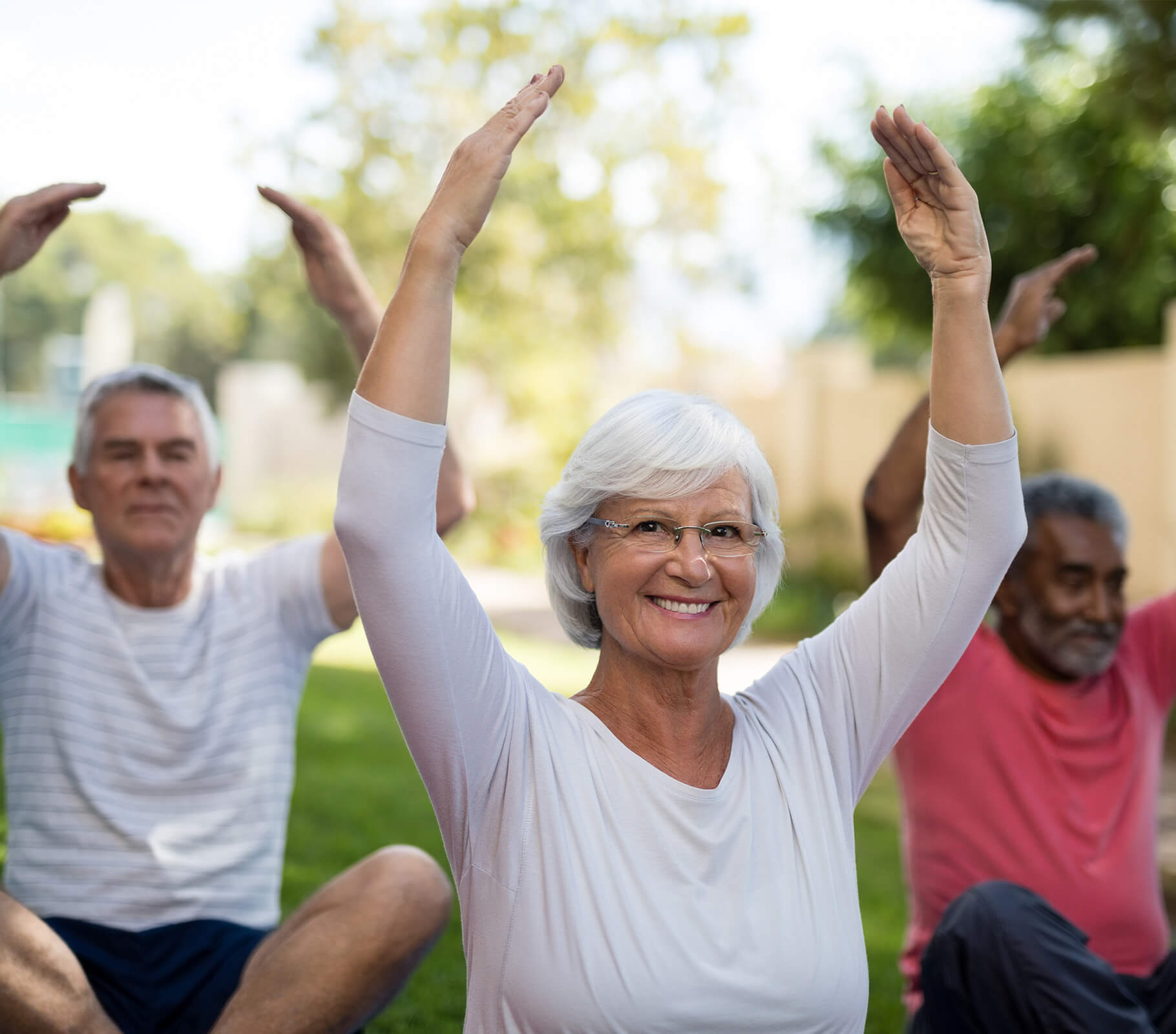 Seniors practicing yoga outdoors in a community garden setting.