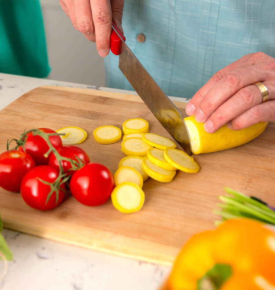 Close up of woman chopping vegetables on cutting board
